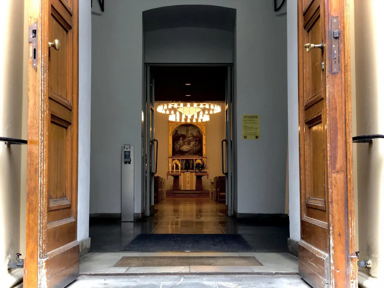 Blick durch die geöffnete Eingangstür der Luisenkirche in den Altarraum.