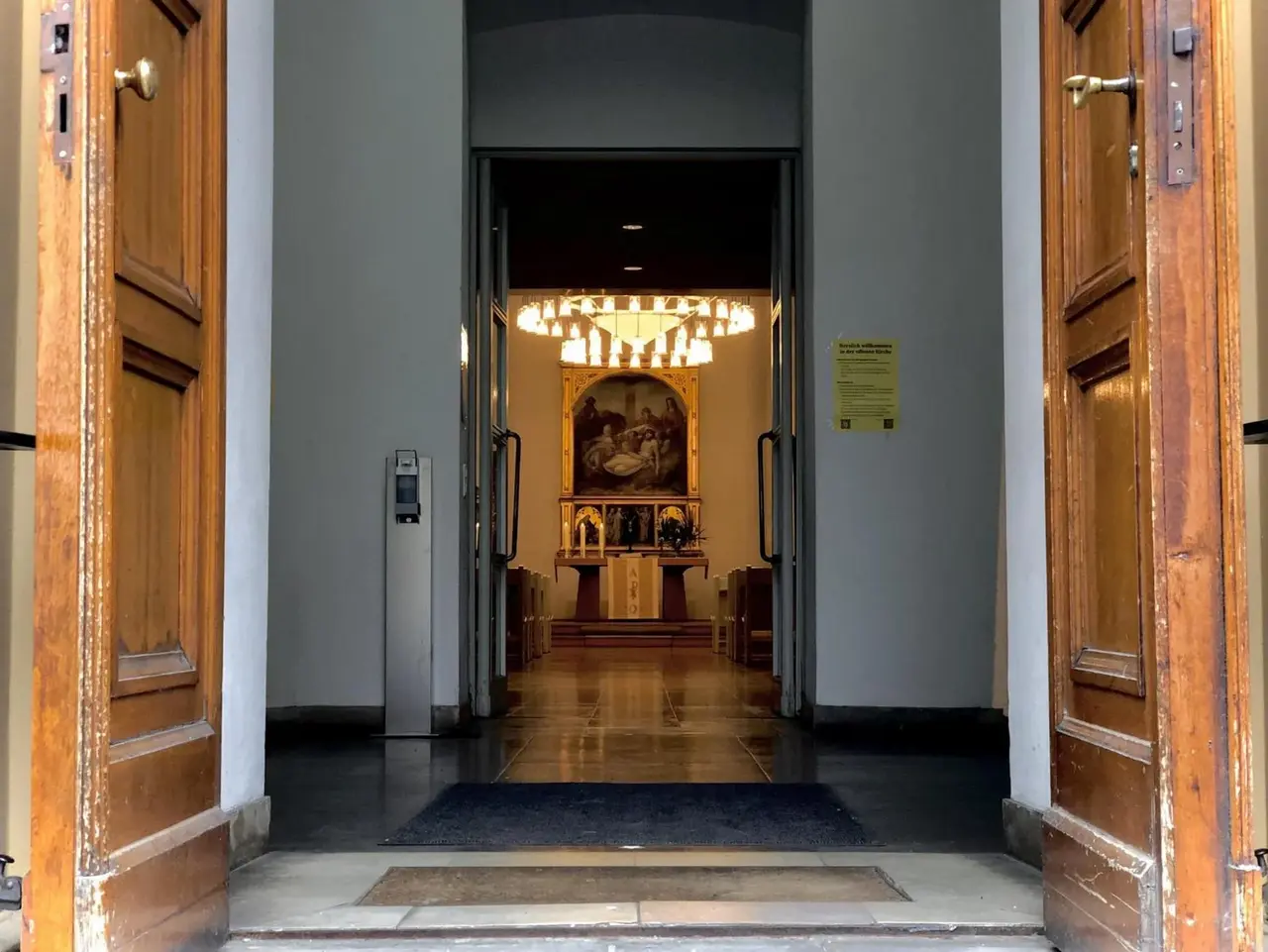 Blick durch die geöffnete Eingangstür der Luisenkirche in den Altarraum.