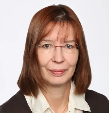 Portrait-Bild der Küsterin Katrin Marsotto: helle Bluse, darüber ein dunkler Pulli. Halblange, brünette Haare, Brille.